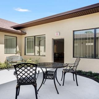 A cozy outdoor patio area with a table and chairs in a courtyard setting.