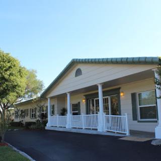 A charming residential building featuring a welcoming front porch and manicured landscaping.