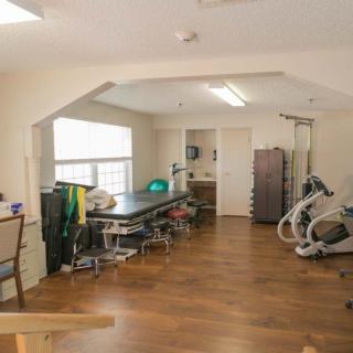 A spacious therapy room equipped for physical rehabilitation.