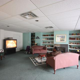A cozy living room with a television, sofas, bookshelves, and a fireplace.