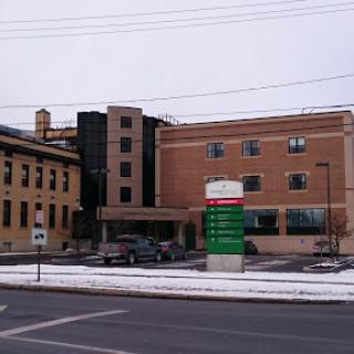 A view of a hospital building during winter, with snow on the ground.