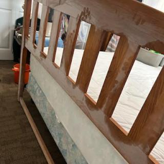 A wooden bed frame with a unique design featuring cut-out sections.