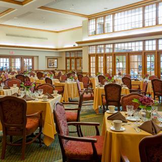 An elegant dining room set up with tables and chairs, ready for guests.