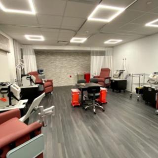 An empty modern clinic room with medical chairs and equipment.