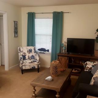 A cozy living room with a sofa, armchair, coffee table, and TV.