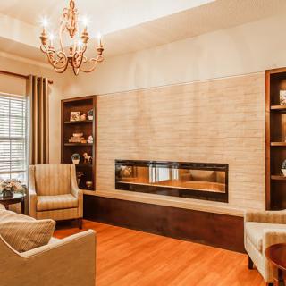 A warm and inviting living room featuring a modern fireplace, elegant chandelier, and comfortable seating.