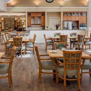 An empty dining area with wooden tables and chairs, featuring a modern and cozy interior design.