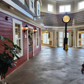 A spacious indoor area featuring a blend of modern architecture and decorative elements, highlighted by a central clock.