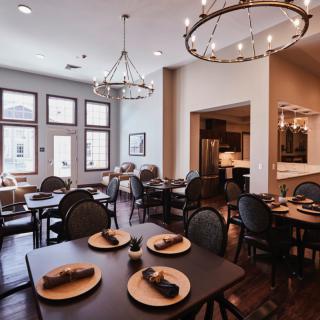 A modern restaurant dining area with elegant furnishings and decorative chandeliers.