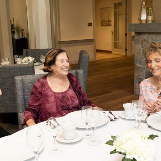 A group of people enjoying a conversation at a dining table.