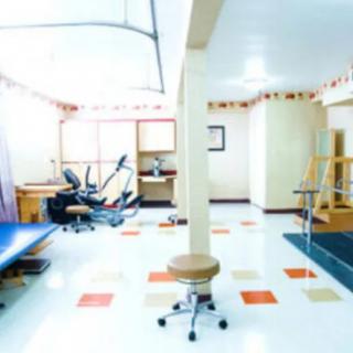 A brightly lit rehabilitation clinic with various therapy equipment.