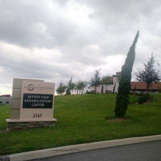 A view of a property sign with cloudy skies in the background.