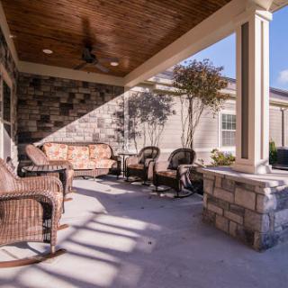 A cozy outdoor patio space featuring comfortable seating and stone accents, perfect for relaxation.