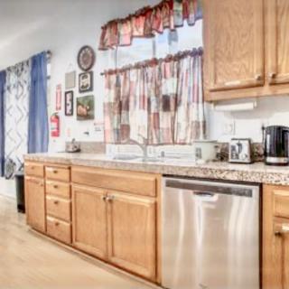 A modern kitchen with wooden cabinets, a countertop, and stainless steel appliances.