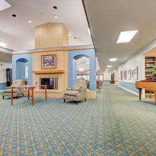 A spacious lobby featuring a central fireplace and comfortable seating.