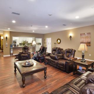 A spacious living room featuring leather sofas, a wooden coffee table, and elegant decor.