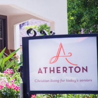 A sign for Atherton, featuring a landscaped garden setting.
