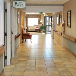 A well-lit hallway with tiled flooring and seating areas.