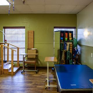 A well-equipped physical therapy room featuring wooden steps and exercise equipment for rehabilitation.