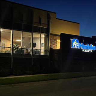 A healthcare facility illuminated at night, showcasing its modern architecture and clear signage.