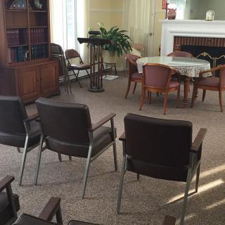 An empty waiting room with arranged chairs and a small table.