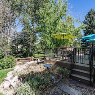 A serene backyard space featuring vibrant umbrellas and lush greenery, perfect for relaxation.