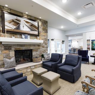 A modern and cozy living room featuring a stone fireplace and comfortable seating.