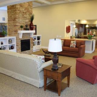 A cozy living room featuring a blend of comfortable seating, a stone fireplace, and decorative elements.