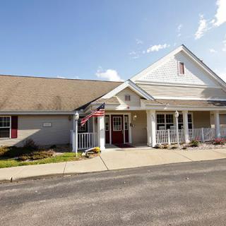 A suburban building with a front porch and pitched roof, captured on a sunny day.