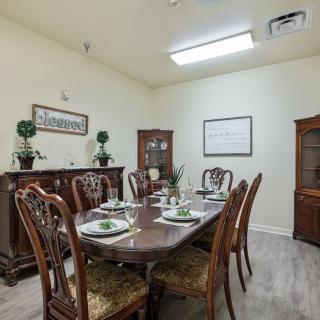 A well-decorated dining room featuring a large wooden table and ornate chairs, complemented by stylish decor.