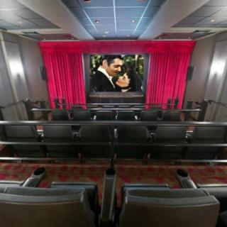 A luxurious home theater featuring comfortable seating and a large movie screen.