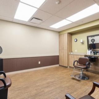 An empty barbershop interior with chairs and a mirror.