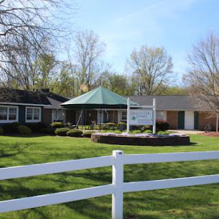 A picturesque view of a charming residence with a gazebo and well-maintained lawn.