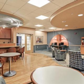 A modern lounge area with comfortable seating and tables under soft lighting.