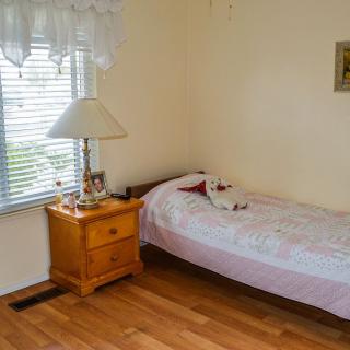 A small, cozy bedroom with a single bed and nightstand.