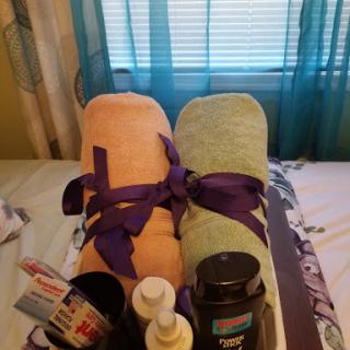 A cozy setup for a relaxing spa day at home, featuring neatly rolled towels and personal care items.