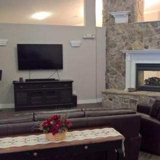 A cozy living room with a modern fireplace and a wall-mounted television.