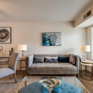 A modern living room with a stylish sofa, decorative artwork, and elegant lighting.
