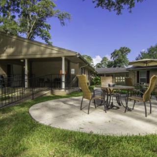 A sunny outdoor patio area with a table and chairs.
