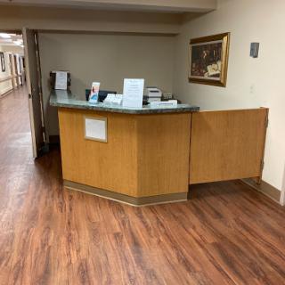 A well-lit reception area with a wooden desk and a welcoming atmosphere.