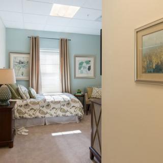 A well-decorated bedroom featuring a comfortable bed, elegant curtains, and wall art.