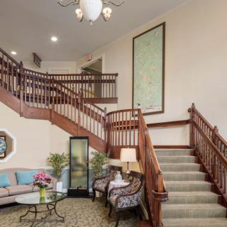 A welcoming lobby with a grand staircase and cozy seating area.