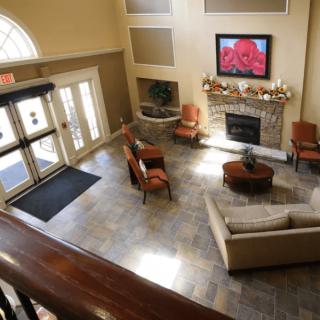 A cozy lobby area with comfortable seating, a fireplace, and a television.