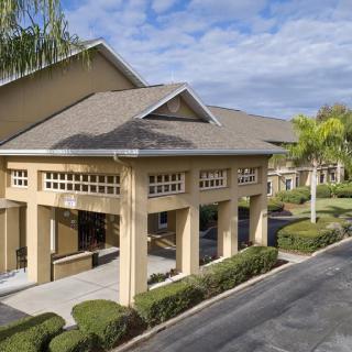 A hotel entrance surrounded by well-maintained landscaping and palm trees.