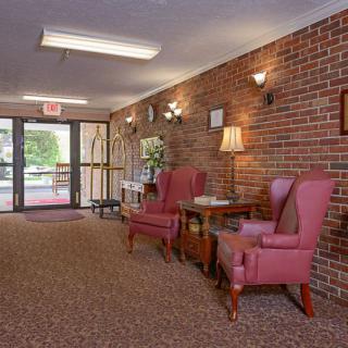Cozy lobby area with brick walls, comfortable chairs, and warm lighting.