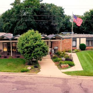 A picturesque view of a suburban home with a lush front yard and an American flag waving proudly.