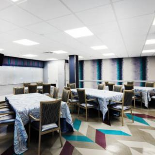 A modern conference room setup with tables and chairs arranged for a meeting.