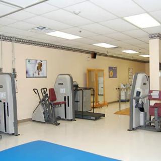 A gym with various exercise machines and equipment.