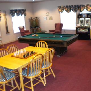A cozy game room featuring a pool table and a chess setup on a dining table.