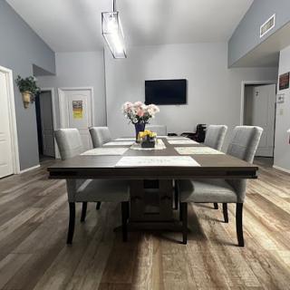 A spacious and modern dining room featuring a large table, comfortable chairs, and tasteful decor.